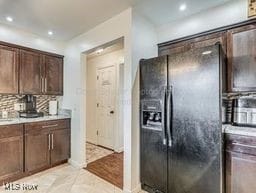 kitchen with decorative backsplash, black fridge with ice dispenser, and light hardwood / wood-style flooring