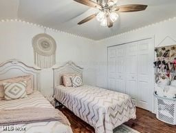 bedroom featuring ceiling fan, a closet, and dark wood-type flooring