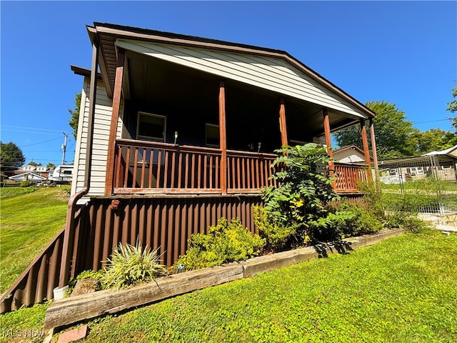 view of side of property featuring a lawn and a deck