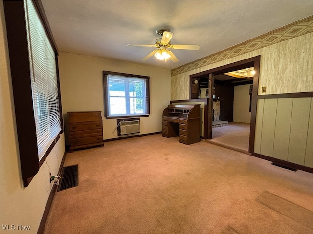 interior space with ceiling fan, carpet floors, and a wall mounted air conditioner