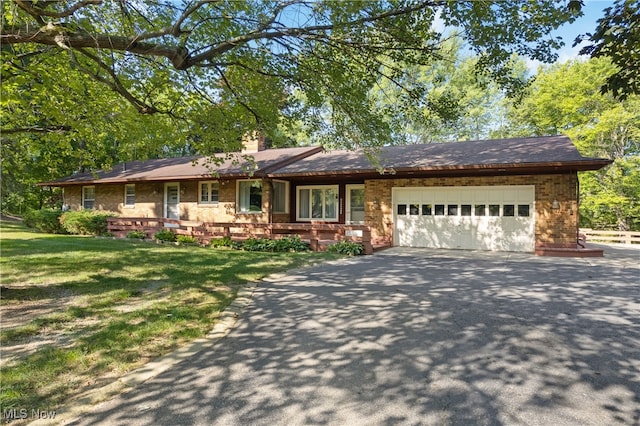 ranch-style home with a garage and a front lawn