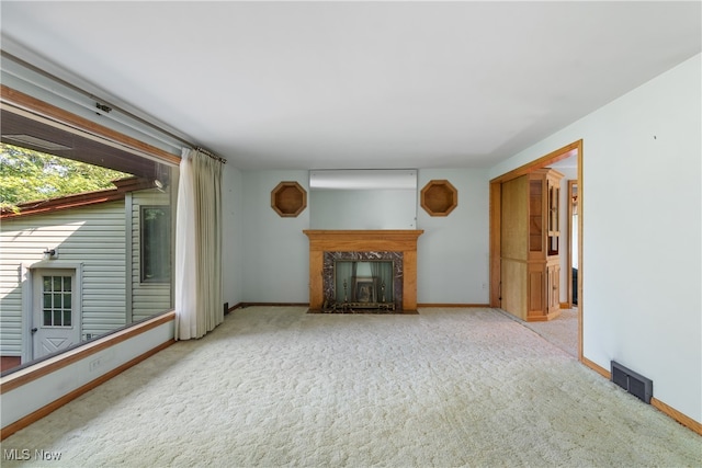 unfurnished living room with carpet flooring and a fireplace