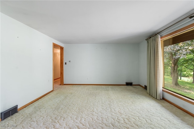 spare room with light colored carpet and plenty of natural light