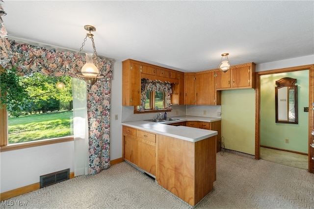 kitchen with light carpet, sink, and hanging light fixtures