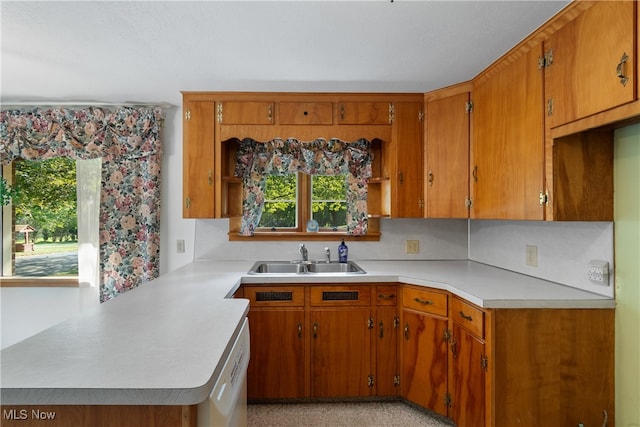 kitchen featuring kitchen peninsula, sink, and white dishwasher