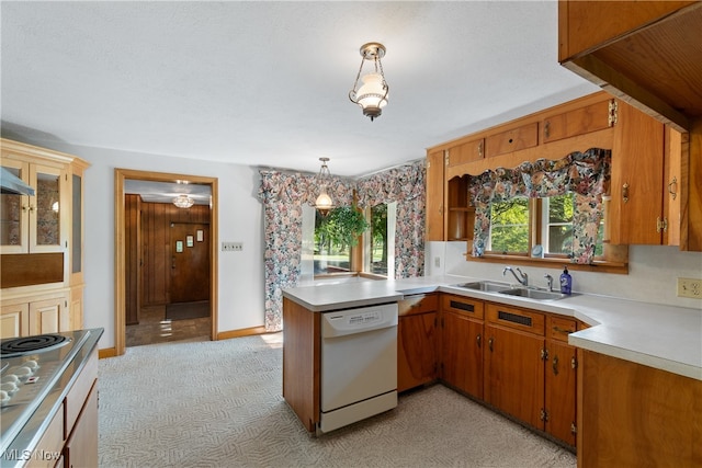 kitchen with white dishwasher, pendant lighting, kitchen peninsula, sink, and light colored carpet