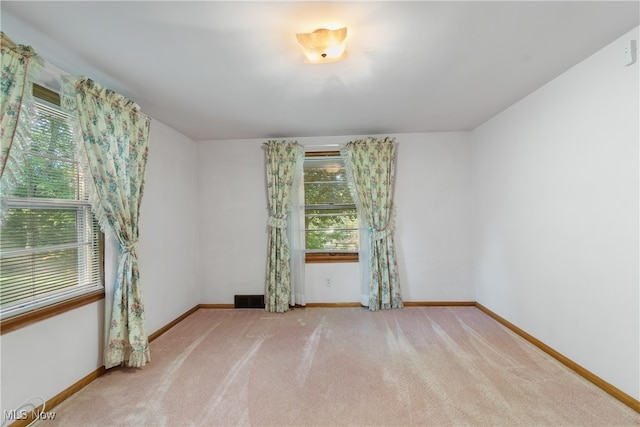 spare room with light colored carpet and a healthy amount of sunlight