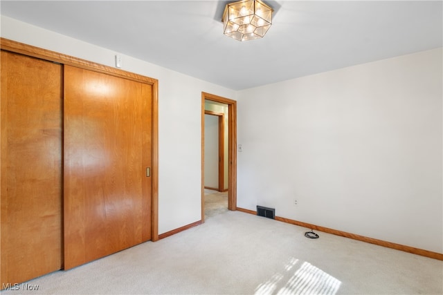 unfurnished bedroom with a closet and light carpet