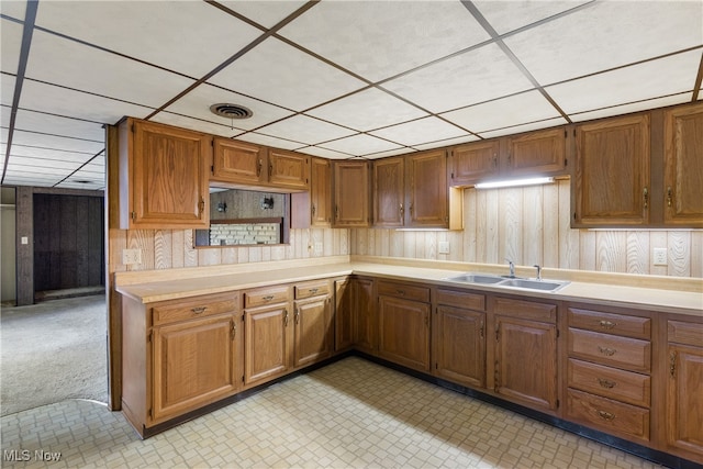 kitchen with a paneled ceiling and sink