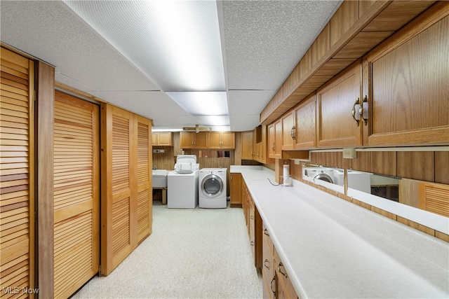 interior space featuring sink, washer and dryer, light colored carpet, and wooden walls