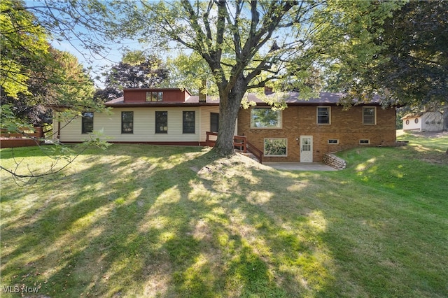 back of house featuring a patio area and a lawn