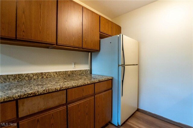 kitchen featuring hardwood / wood-style floors and white fridge