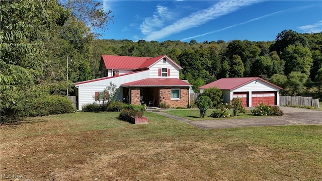 view of front of house featuring an outbuilding, a garage, and a front lawn