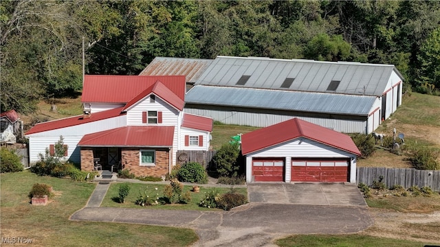 view of front of home with an outdoor structure, a garage, and a front lawn