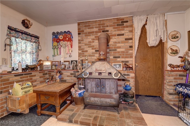 sitting room with a wood stove and brick wall