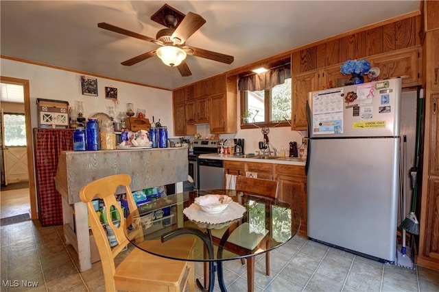 kitchen with plenty of natural light, ceiling fan, ornamental molding, and appliances with stainless steel finishes