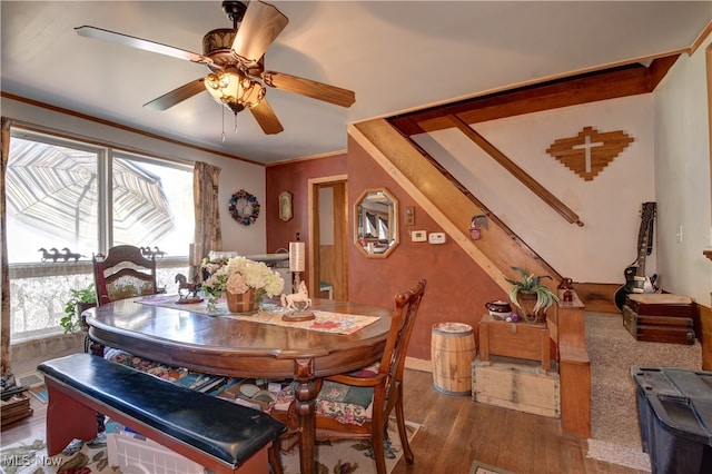 dining space with ornamental molding, dark wood-type flooring, and ceiling fan