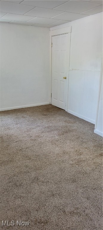 carpeted empty room featuring a paneled ceiling