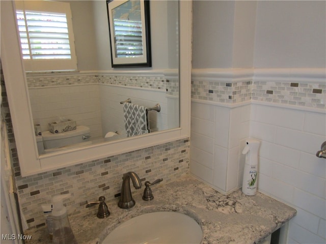 bathroom with tasteful backsplash and vanity