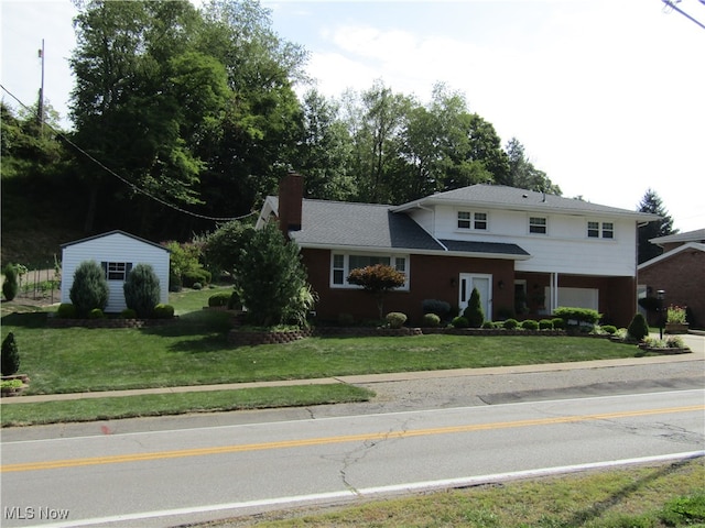 view of front of property featuring a front lawn and a storage unit