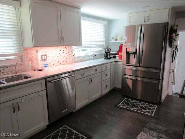 kitchen with white cabinetry, appliances with stainless steel finishes, dark hardwood / wood-style flooring, and light stone countertops