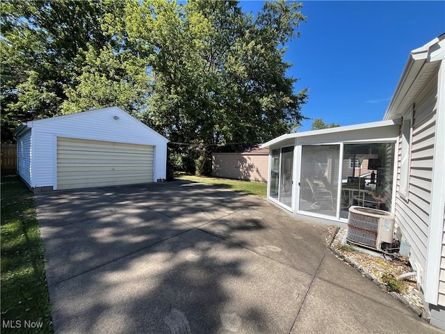 view of patio / terrace with an outdoor structure, a garage, and central AC unit