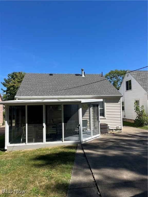 back of property featuring a yard, a patio area, a sunroom, and central AC