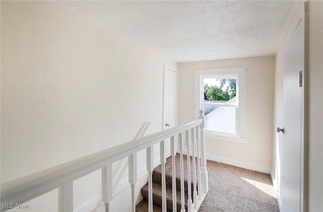 corridor featuring a textured ceiling and carpet floors