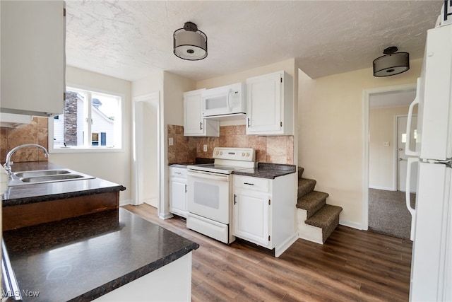 kitchen with white appliances, tasteful backsplash, sink, dark hardwood / wood-style floors, and white cabinets