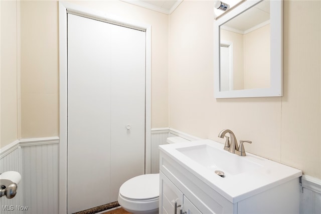 bathroom featuring ornamental molding, vanity, and toilet