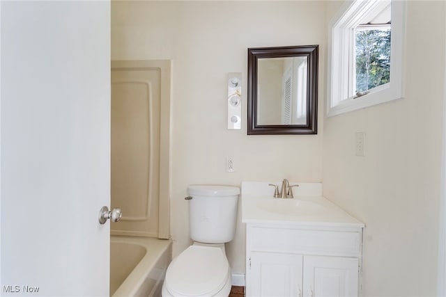 bathroom featuring vanity, toilet, and a washtub