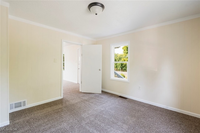 carpeted empty room featuring crown molding