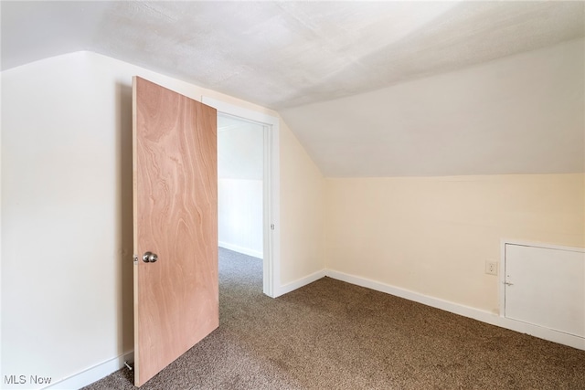 additional living space featuring carpet flooring and vaulted ceiling