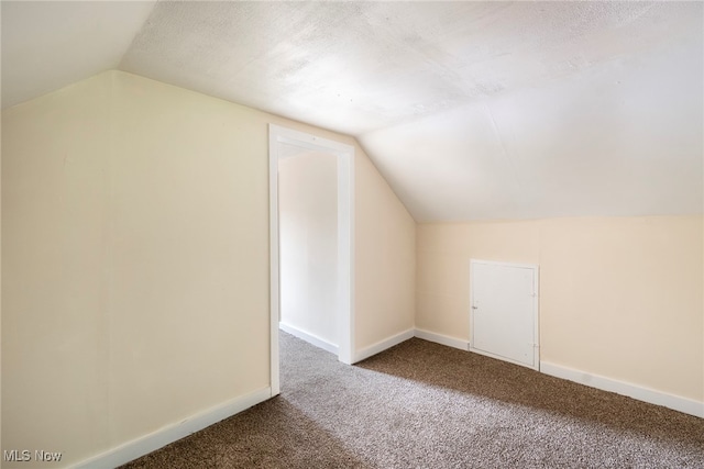 bonus room with vaulted ceiling, a textured ceiling, and carpet floors