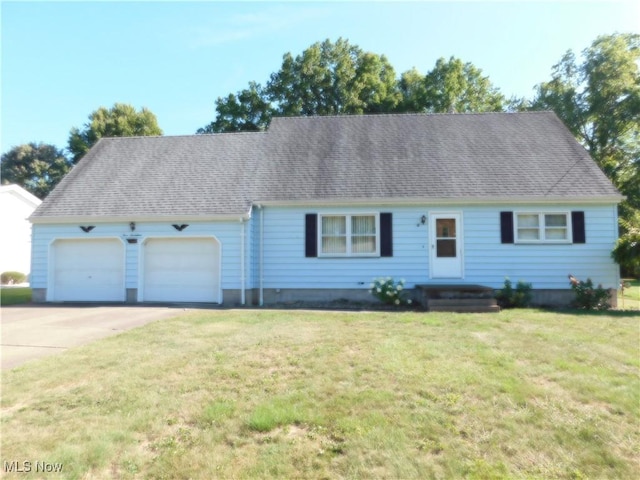 view of front of house with driveway, a front yard, a garage, and roof with shingles