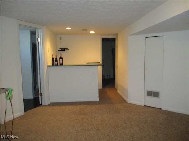 interior space featuring a textured ceiling and carpet flooring