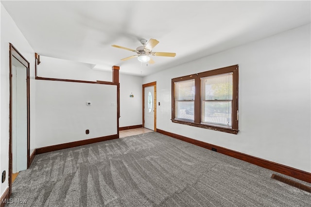 carpeted spare room with ceiling fan