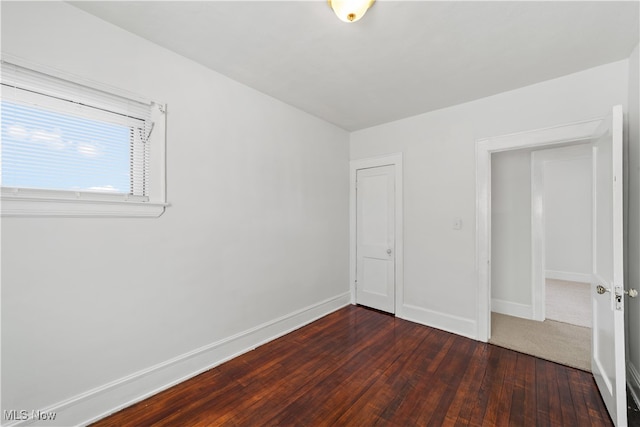 unfurnished bedroom featuring a closet and dark hardwood / wood-style floors