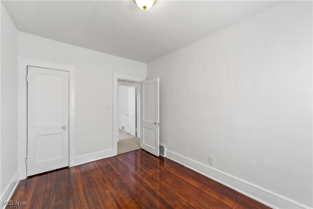 unfurnished bedroom with dark hardwood / wood-style floors