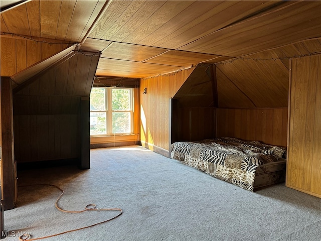 unfurnished bedroom with wooden ceiling, wood walls, and carpet floors