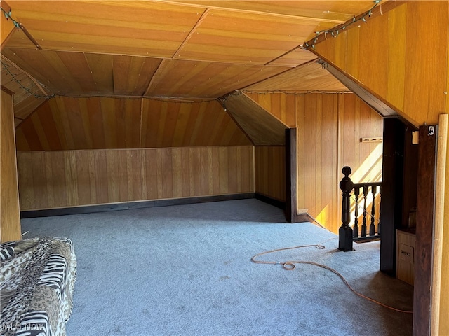 additional living space with lofted ceiling, wood ceiling, wooden walls, and carpet floors