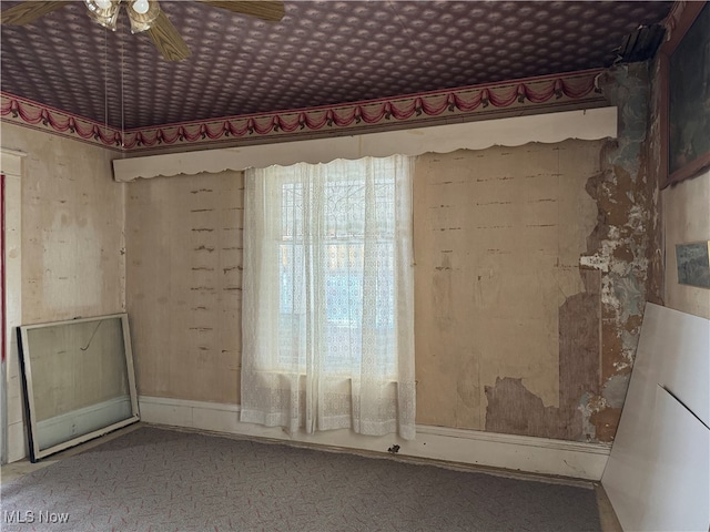 unfurnished room featuring ceiling fan and carpet