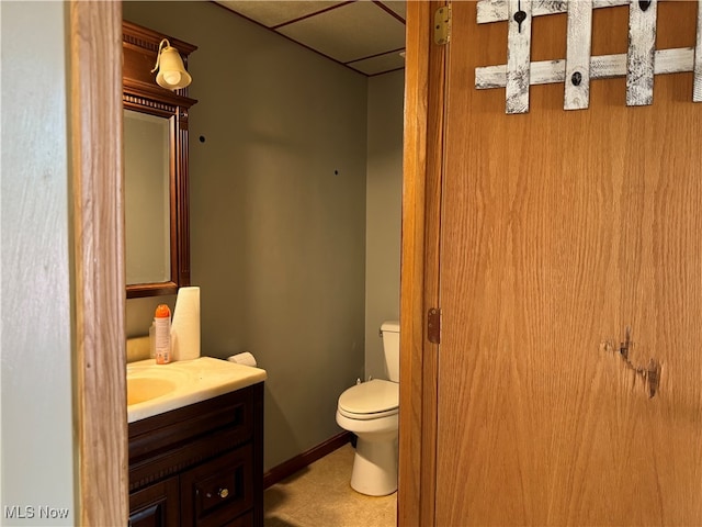 bathroom featuring a paneled ceiling, toilet, and vanity