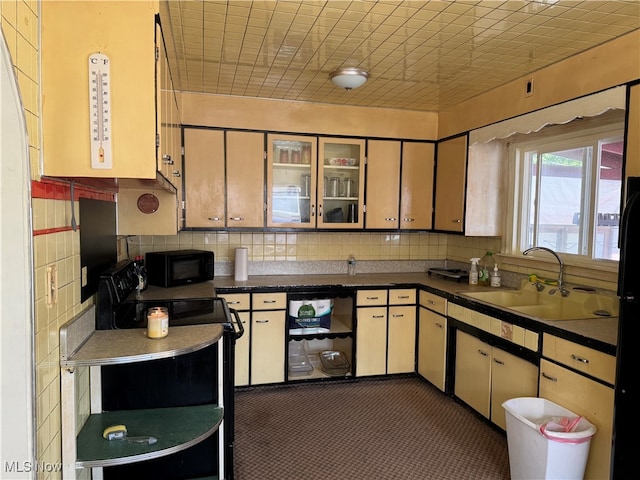 kitchen with black appliances, sink, and backsplash