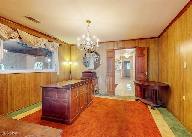 kitchen featuring light colored carpet, a kitchen island, a wealth of natural light, and a chandelier