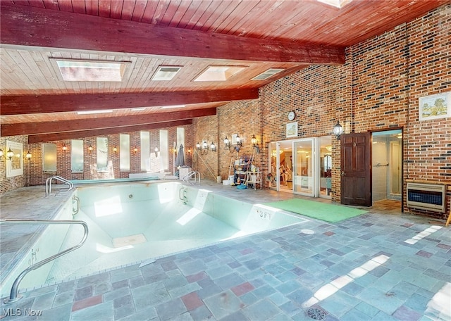 view of pool with a skylight and a jacuzzi