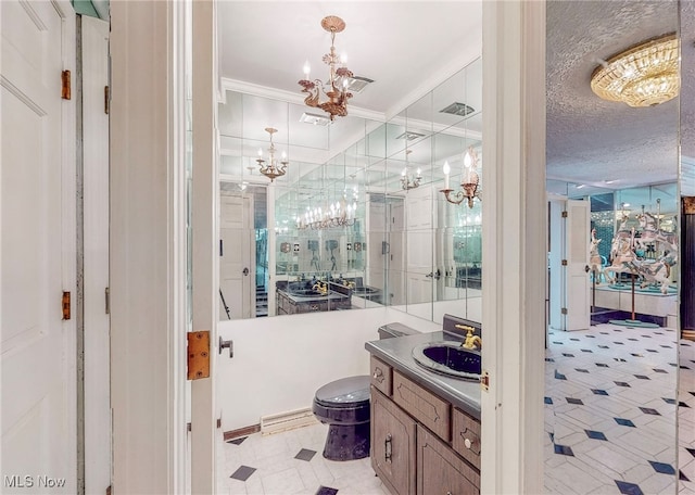 bathroom with a textured ceiling, toilet, a chandelier, vanity, and ornamental molding