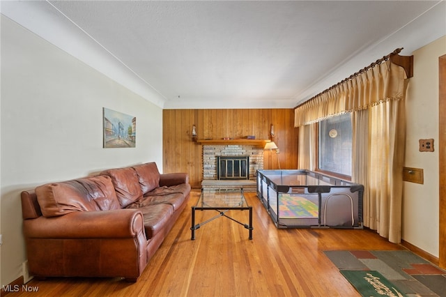 living room featuring a fireplace, hardwood / wood-style floors, and wooden walls