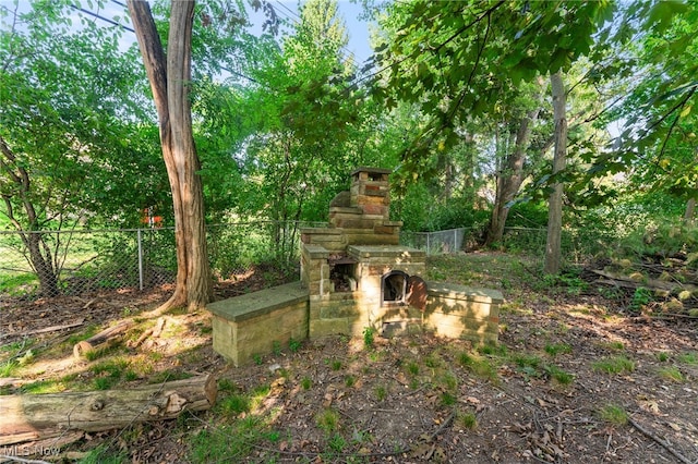 view of yard with an outdoor stone fireplace