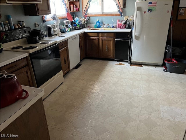 kitchen featuring white appliances, exhaust hood, and sink